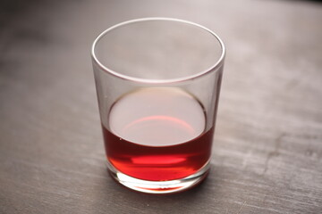 glass with cognac on a dark background top view hard lighting