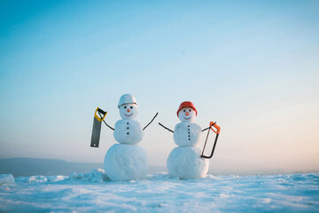 Snowman workers in build helmet in winter. Building and repair work. Happy holiday and celebration....
