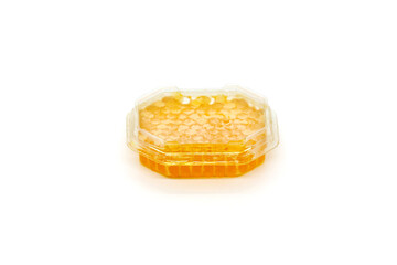 Portion honeycomb  in a plastic container on a white background