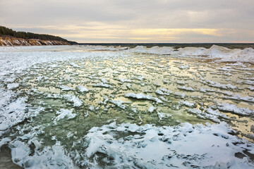 Winter landscape with a river covered with snow and ice hummocks. Ob River, Western Siberia