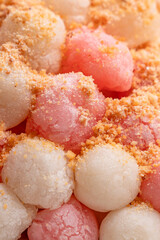 Deep-fried red and white tangyuan with peanut powder.