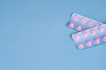 pink pills in packs vitamins pain reliever blue background