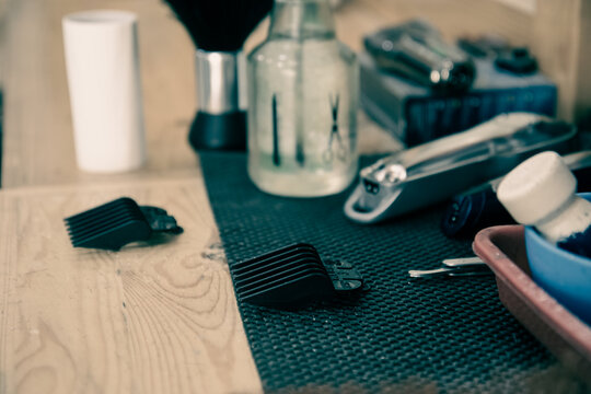A collection of hairdressing tools and accessories on a table. Stylish barber tools scattered on a workspace ready for use. Hairdressing essentials laid out for a professional setup