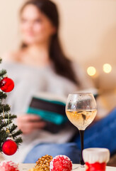 There is a glass of wine and a Christmas tree on the table