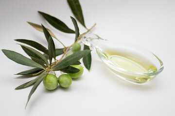 Fresh ripe green olives branch in an olive oil in glass bowl