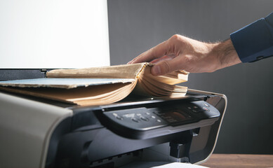 Man copying a book on a copy machine.