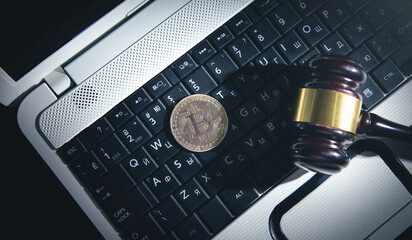 Bitcoin and gavel on the laptop keyboard.
