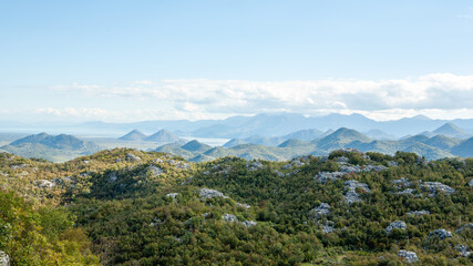 The horizontal landscape of green mountains and blue sky with white clouds. Summer landscape in mountains. Travel trip background for a post, screensaver, wallpaper, postcard, poster, banner, cover