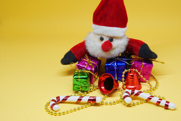 Santa claus doll and Many presents gift box - Xmas or Christmas  concept on yellow background