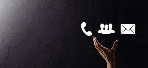 Hand hold icon symbol telephone, email, contact. Website page contact us or e-mail marketing concept on dark beton background