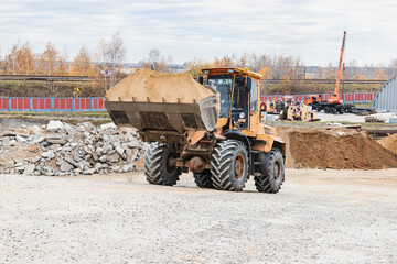 The excavator backfills the pit with the front bucket. Moves soil around the construction site....
