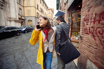 A young girl in a yellow raincoat bumped into a passerby while talking on the smartphone and...