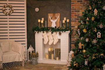 Cozy room with a Christmas atmosphere. Burning fireplace, glowing Christmas tree. Comfortable home environment with candles. Spirit of Christmas and New Year.