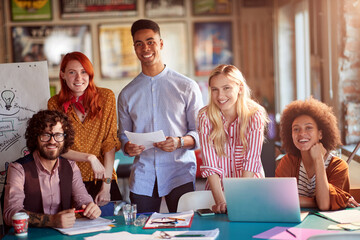 Group of happy employees are posing for a photo while working in the office together