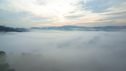 Fototapeta na wymiar aerial view mist above the mountain in tropical rainforest and .beautiful sunrise scenery view in Phang Nga valley.