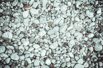 Sea pebbles on the beach. Close-up shot. Small and big roundish smooth stones. Texture of beach pebbles for a post, screensaver, wallpaper, postcard, poster, banner, cover, header for a website
