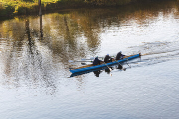 Ein Dreier Ruderboot mit alten Herren auf einem Fluß