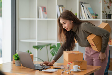 Young Asian women working with boxes for packaging order from shopping online in home, Own Business Startup.