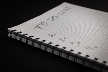 Planing on New Year To Do list concept. Notebook with empty list on black bacground. Shallow depth of field .