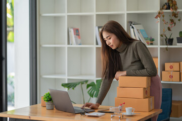 Young Asian women working with boxes for packaging order from shopping online in home, Own Business Startup