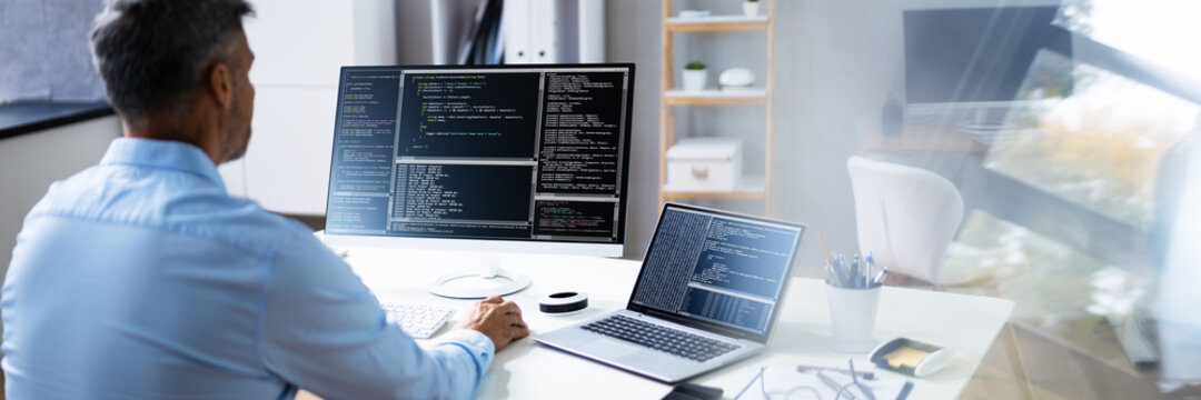 Computer Programmer Writing Program Code On Computer