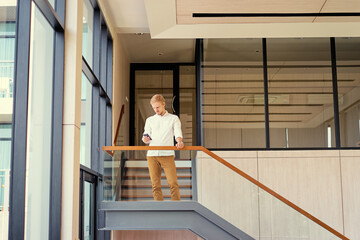 Business and technology. Handsome young man using smartphone in office.