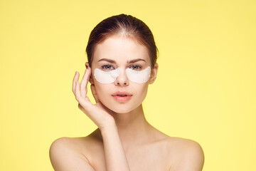 woman with bare shoulders and punchy rejuvenation skin care yellow background