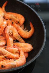 the cook fries shrimps in garlic sauce in a frying pan close-up. asian shrimp in sauce close-up