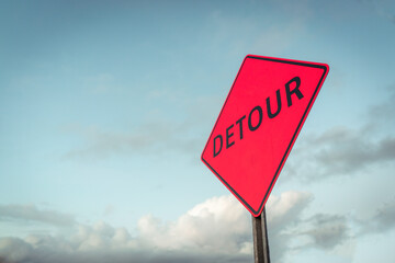 Simple detour sign in front of clouds and blue sky