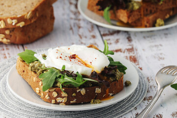 Homemade sandwiches with pesto, green salad and poached eggs