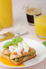 Breakfast with a sandwich with poached egg and avocado