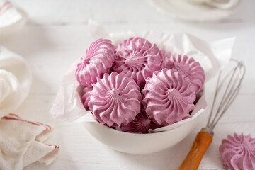 Italian and French meringue in a white plate on a light culinary background