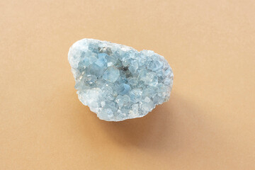 Blue celestine crystal stone mineral gemstone. Natural azure rough Celestite crystals cluster on beige background, close up. Top view