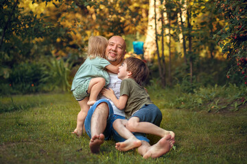 A boy and little girl are hugging their father  in summer park. Image with selective focus and toning