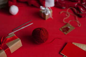 Red yarn and crocheti hooks on red background with christmas decor - holidays and hobby