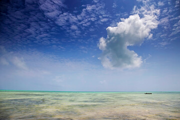 Turquoise waters of Indian ocean with blue cloudy sky, Zanzibar, Tanzania