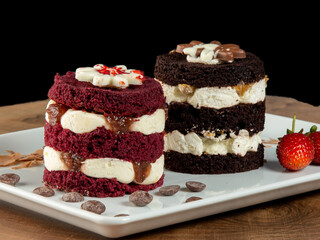 Strawberry and chocolate cakes on white plate on wood