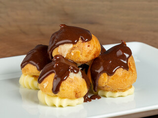 beautiful muffins with chocolate sauce on white plate on wood