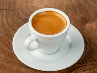 Obraz premium frothy coffee in white cup wood background