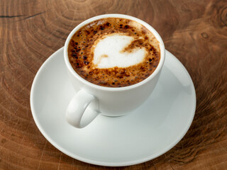 coffee in heart shaped white cup and wood background