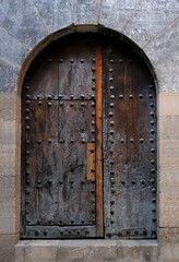 Fototapeta na wymiar Old wooden door in stone wall