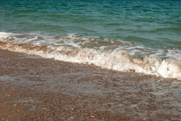Soft sea wave beat on sandy shore closeup
