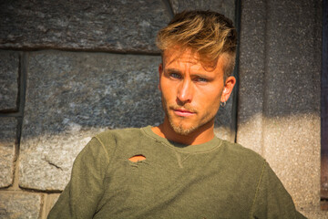 Handsome young man against stone wall outside