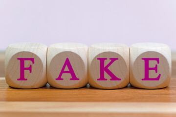 Vier Holzwürfel mit dem Aufdruck Fake