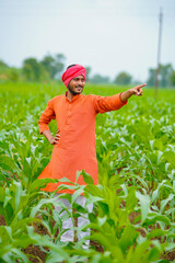 young indian farmer at corn field.