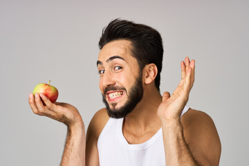 a man in a white t-shirt fresh fruit apples vitamins isolated background