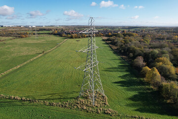High voltage post,High voltage tower sky field grass housing esate aerial drone view - obrazy, fototapety, plakaty