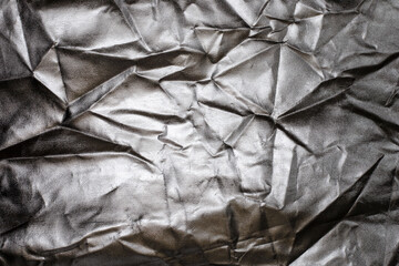 Silver foil texture, shiny and folded. Abstract silver background.
