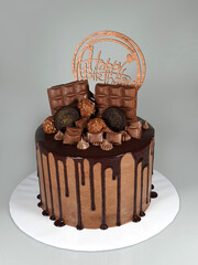 Chocolate cake with fresh chocolates decorated as topping and chocolate ganache