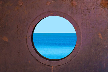Porthole with ocean view. View of the silent sea surface through a rusty porthole of the ship. Old ship cabin window
